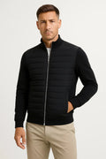 Hybrid quilted jacket with knitted sleeves in black, front view