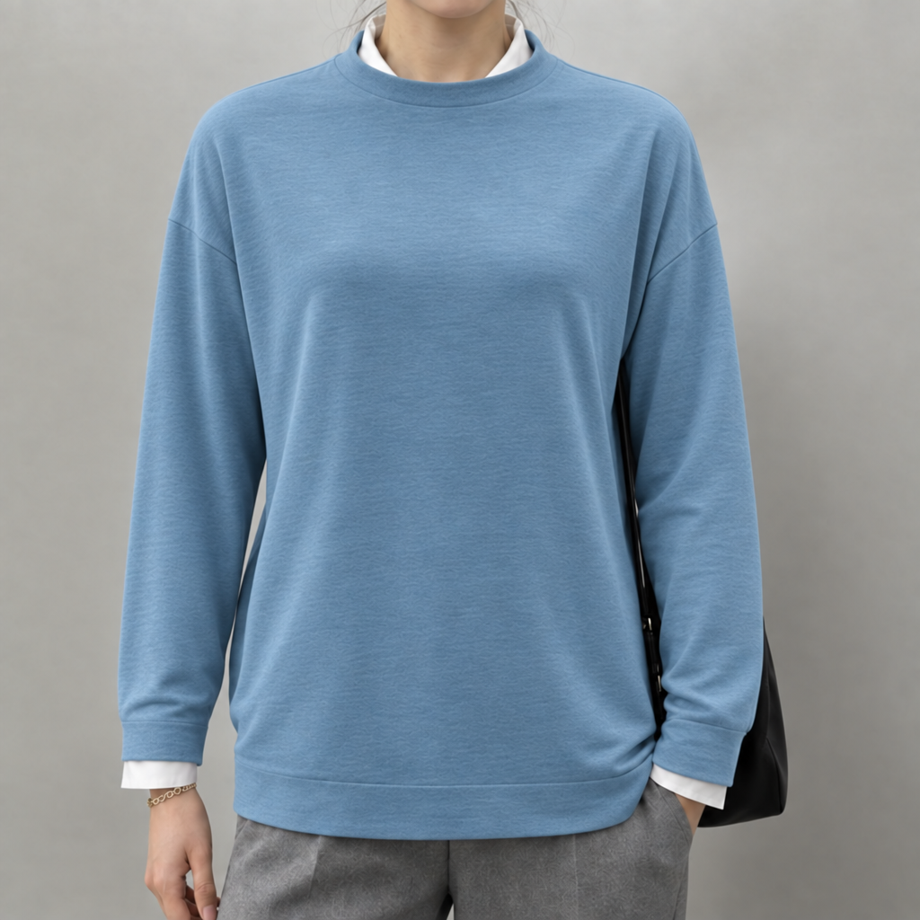 Blue lightweight round neck jumper layered over a white shirt, worn by a model