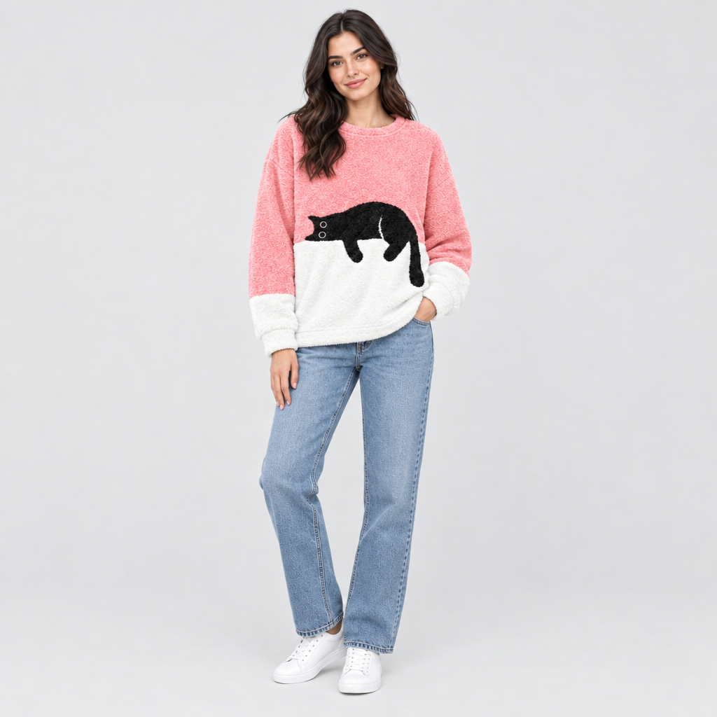 Model wearing pink plush fleece jumper with sleeping cat print, styled with jeans and white trainers