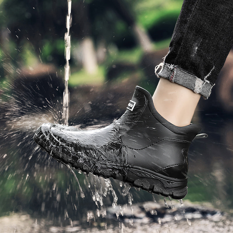 Waterproof ankle height rain boots in black, side view